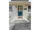 Inviting front entryway with a teal door, decorative columns, and a brick step at 223 Grove St, Charleston, SC 29403
