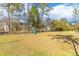 Spacious backyard features mature trees and a play set at 233 Ashmont Dr, Wando, SC 29492