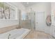 Bright bathroom featuring a soaking tub and glass shower with tile surround at 233 Ashmont Dr, Wando, SC 29492
