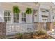 Inviting front porch with hanging plants, brick supports, and classic white railings at 233 Ashmont Dr, Wando, SC 29492