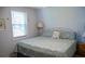 Serene bedroom with a queen bed, soft blue walls, and natural light from a large window at 259 Sea Cloud Cir, Edisto Island, SC 29438