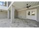 Spacious covered patio area with exposed aggregate pillars, ceiling fans, and a door to access the home's interior at 2607 Cameron Blvd, Isle of Palms, SC 29451