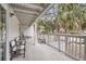 Wide covered porch with outdoor seating overlooking a lush, tropical landscape at 263 Sea Cloud Cir, Edisto Island, SC 29438