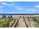 Direct beach access with wooden walkway, chairs and umbrellas, perfect for relaxing by the ocean at 263 Sea Cloud Cir, Edisto Island, SC 29438