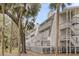 Exterior view of multi-story townhomes with private balconies and tropical tree surround at 263 Sea Cloud Cir, Edisto Island, SC 29438