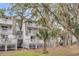 Multi-story townhomes featuring private balconies and staircases surrounded by mature trees at 263 Sea Cloud Cir, Edisto Island, SC 29438