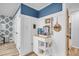 Hallway with wood-look flooring, white wainscoting, and a serving cart stocked with coffee supplies and beach-themed decor at 263 Sea Cloud Cir, Edisto Island, SC 29438