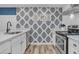 Bright kitchen featuring modern appliances, white cabinetry, and stylish accent wallpaper at 263 Sea Cloud Cir, Edisto Island, SC 29438