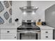Close-up of a modern stainless steel oven and range with white cabinets and backsplash at 263 Sea Cloud Cir, Edisto Island, SC 29438