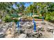 Outdoor community patio area featuring pavers, seating, blue umbrellas, and lush landscaping at 263 Sea Cloud Cir, Edisto Island, SC 29438