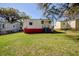 Expansive backyard view with mature trees and neighboring houses beyond the green lawn at 2641 Woodlawn Ave, North Charleston, SC 29405