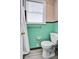 This bathroom features green tile walls, white fixtures, and new flooring at 2641 Woodlawn Ave, North Charleston, SC 29405