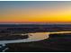 A scenic aerial view of a marsh during sunset, reflecting golden light at 2722 Crooked Stick Ln, Mount Pleasant, SC 29466