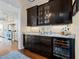 Elegant bar area featuring dark wood cabinets, granite countertops, wine refrigerator and glass storage, perfect for entertaining at 2722 Crooked Stick Ln, Mount Pleasant, SC 29466