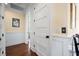 Bright hallway showcasing white trim and doors, wainscoting, and hardwood flooring with an alarm panel at 2722 Crooked Stick Ln, Mount Pleasant, SC 29466