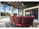 Covered outdoor seating area with red cushioned chairs, TV, ceiling fan, and view of pool at 2722 Crooked Stick Ln, Mount Pleasant, SC 29466