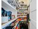 Organized walk-in pantry with white shelving stocked with food items and cooking utensils, for efficient kitchen storage at 2722 Crooked Stick Ln, Mount Pleasant, SC 29466