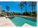 Gorgeous pool with travertine surround, spa, and lounge chairs overlooking manicured backyard and mature trees at 2722 Crooked Stick Ln, Mount Pleasant, SC 29466