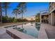 Lovely in-ground pool and spa with travertine patio, lounge chairs, and landscaped backyard at sunset at 2722 Crooked Stick Ln, Mount Pleasant, SC 29466