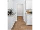Bright kitchen featuring white cabinetry, granite countertops and wood flooring, leading to a pantry at 280 Watersglen Dr, Summerville, SC 29486
