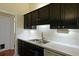 This kitchen has a double sink, dishwasher, plenty of counter space, and dark cabinets with white backsplash at 3438 Farmers Market Dr, Charleston, SC 29414