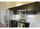Bright kitchen showcasing stainless steel appliances, dark cabinets, and well-lit countertops for meal preparation at 3438 Farmers Market Dr, Charleston, SC 29414