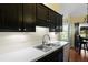 This kitchen boasts a view to the exterior, a large double sink, dishwasher, and dark cabinets with white backsplash at 3438 Farmers Market Dr, Charleston, SC 29414