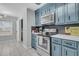 Stylish kitchen boasts blue cabinetry, stainless steel appliances, and a modern backsplash at 346 Courtney Round, Summerville, SC 29483
