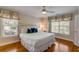 Bedroom features hardwood floors, large bed, ceiling fan, and large windows with custom valances at 4006 Hartnett Blvd, Isle of Palms, SC 29451