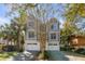 This two-story home features a paved driveway, a two car garage, and mature landscaping at 4006 Hartnett Blvd, Isle of Palms, SC 29451