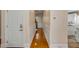Long hallway with beautiful hard wood floors, white walls, and a partial view of a stairway at 4006 Hartnett Blvd, Isle of Palms, SC 29451