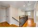 Upstairs hallway with wooden floors and staircase with metal banister at 4006 Hartnett Blvd, Isle of Palms, SC 29451