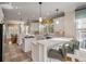 Bright open kitchen featuring white cabinets, stone countertops, an island cooktop, and breakfast bar seating at 4006 Hartnett Blvd, Isle of Palms, SC 29451