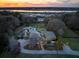 Stunning aerial view of estate home with river access, manicured landscaping, and a private pool at sunset at 4020 Betsy Kerrison Pkwy, Johns Island, SC 29455