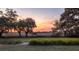 Expansive backyard with mature oak trees and scenic views at sunset at 4020 Betsy Kerrison Pkwy, Johns Island, SC 29455