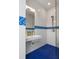 Bright bathroom features a blue tiled floor, minimalist sink, and glass-enclosed shower at 4020 Betsy Kerrison Pkwy, Johns Island, SC 29455