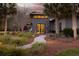 A stylish front entrance features a stone facade, modern lighting, and a walkway surrounded by lush greenery at 4020 Betsy Kerrison Pkwy, Johns Island, SC 29455