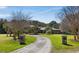 Elegant home entrance with a circular driveway, stone gateposts, and meticulously landscaped grounds for curb appeal at 4020 Betsy Kerrison Pkwy, Johns Island, SC 29455