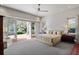Sun-filled main bedroom boasts a cozy sitting area, plush bed, and french doors leading to the outdoor greenery at 4020 Betsy Kerrison Pkwy, Johns Island, SC 29455