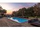 Inviting pool area with comfortable seating, set against a backdrop of lush trees and a colorful sunset at 4020 Betsy Kerrison Pkwy, Johns Island, SC 29455