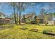 Expansive backyard with green lawn, garden beds, mature trees, and a fence at 406 Mendenhall St, Summerville, SC 29483