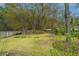 Backyard with a green lawn, garden beds, mature trees, and a wooden fence at 406 Mendenhall St, Summerville, SC 29483
