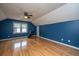 Bright blue bedroom featuring wood floors, a ceiling fan, and a window with natural light at 406 Mendenhall St, Summerville, SC 29483