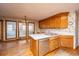 Kitchen area with wooden cabinets, white countertops, and an adjacent sunroom with lots of natural light at 406 Mendenhall St, Summerville, SC 29483