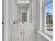 Bright bathroom featuring white cabinetry, large mirror and natural light from the window at 4108 Whiting St, Mount Pleasant, SC 29466