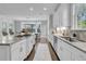 Bright, modern kitchen with white cabinets, granite countertops, and stainless steel appliances overlooking the dining area at 4108 Whiting St, Mount Pleasant, SC 29466