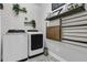 Modern laundry room with front-loading washer and dryer, stylish shelves, and tasteful decor at 4108 Whiting St, Mount Pleasant, SC 29466