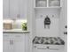 A clean mudroom with white cabinetry, a cushioned bench, hooks, and stylish baskets on the shelf at 4108 Whiting St, Mount Pleasant, SC 29466