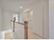 Upstairs hallway with wooden railings leading to a laundry room is bright and airy, and features new carpet at 418 Duskywing Dr, Goose Creek, SC 29445