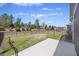 Backyard featuring a black metal fence, a small grass area, and a concrete patio at 422 Switchgrass Dr, Summerville, SC 29486